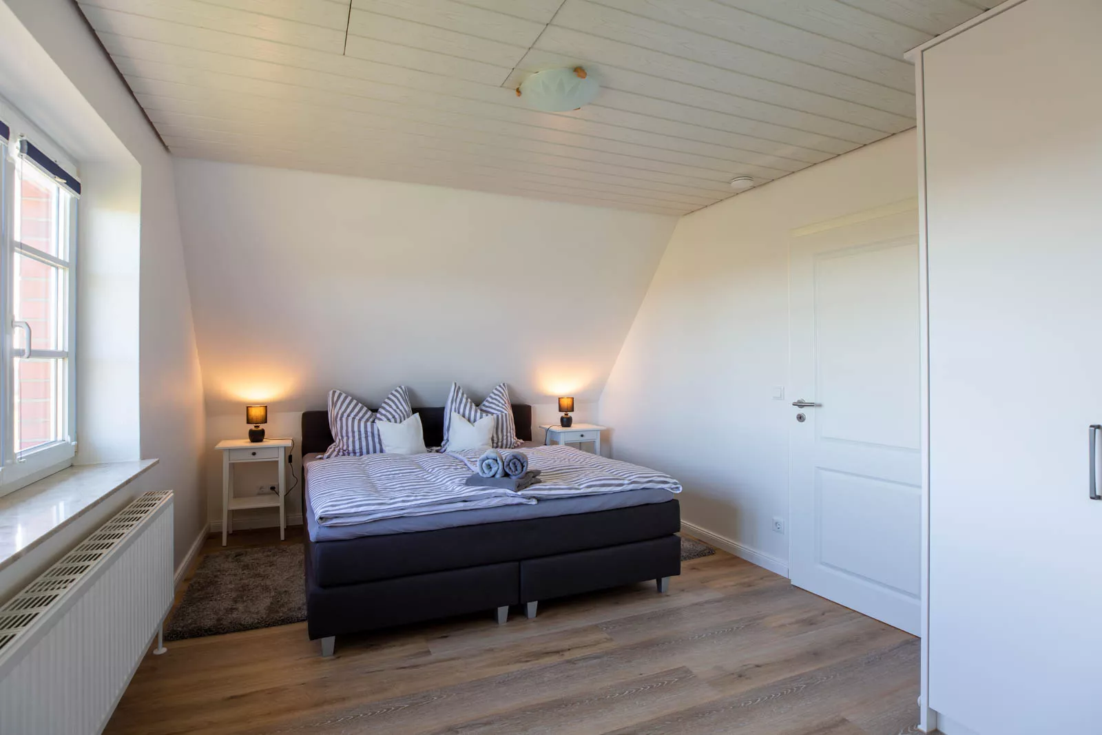 Gemütliches Schlafzimmer mit Doppelbett und Kleiderschrank in der Ferienwohnung auf Pellworm