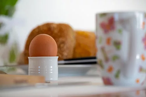 Frühstückstisch mit frischen Brötchen und Ei in der Ferienwohnung auf Pellworm